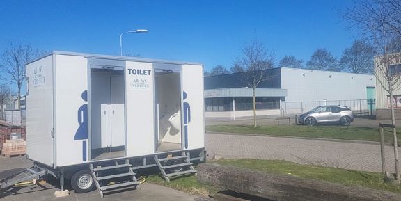 Toiletwagen voor een bedrijfsfeest Toiletwagen van AB-WC Verhuur met geopende deuren, klaar voor een bedrijfsfeest in De Goorn